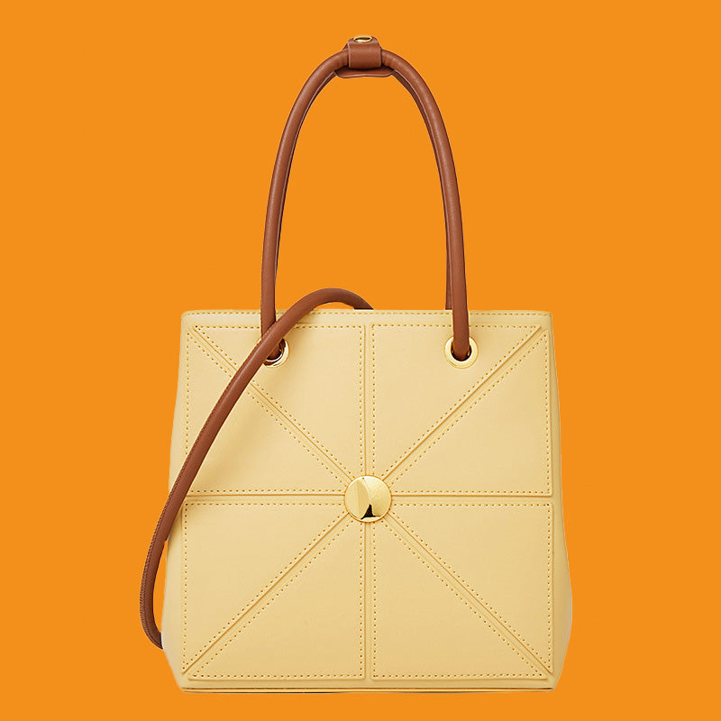 Beige handbag with brown handle on an orange background