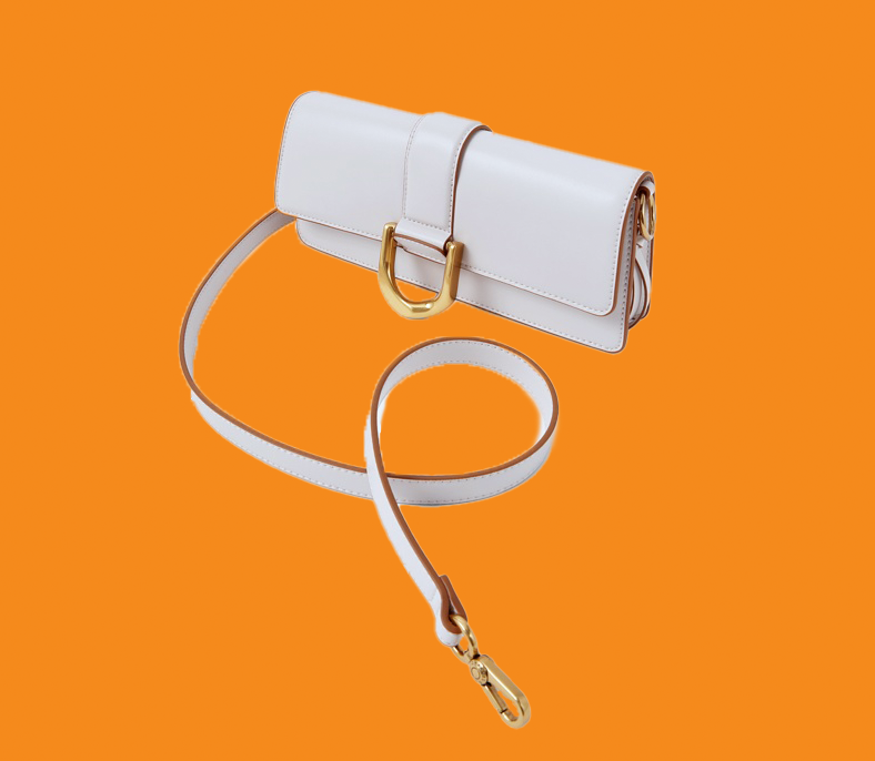 White handbag with gold accents on an orange background