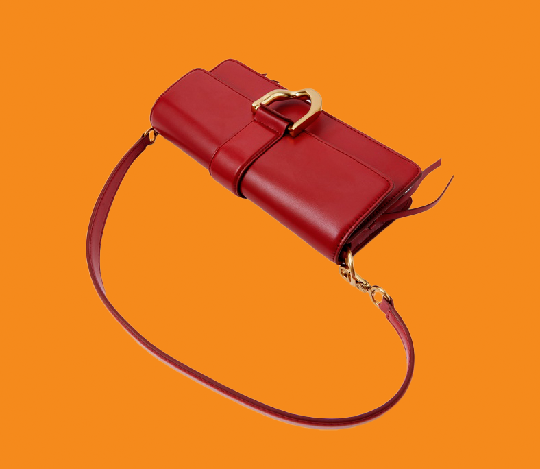 Red handbag with gold accents on an orange background