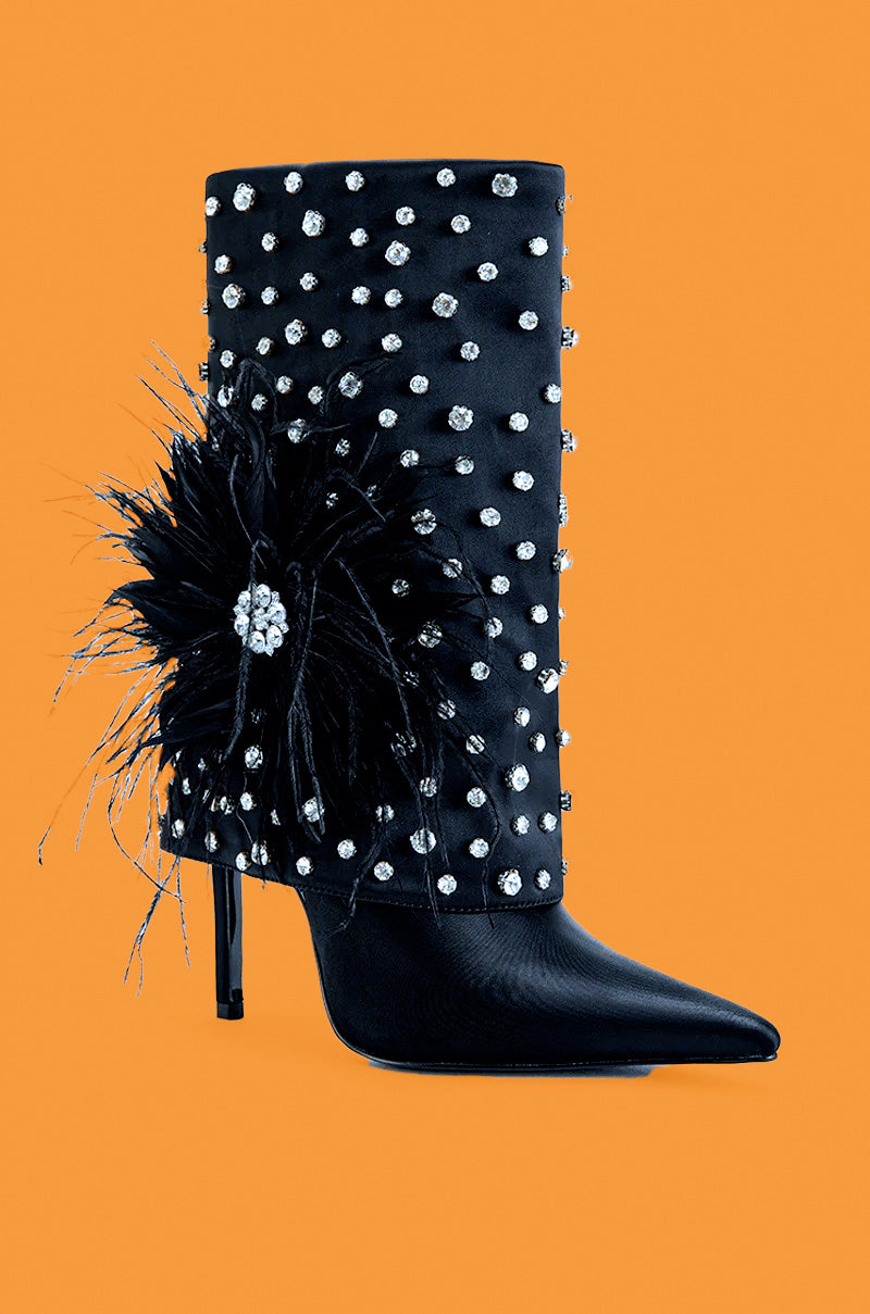 Black stiletto boot with pearl embellishments and a feather detail on an orange background