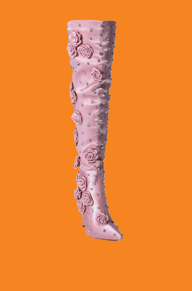 Pink knee-high boot with floral designs on an orange background