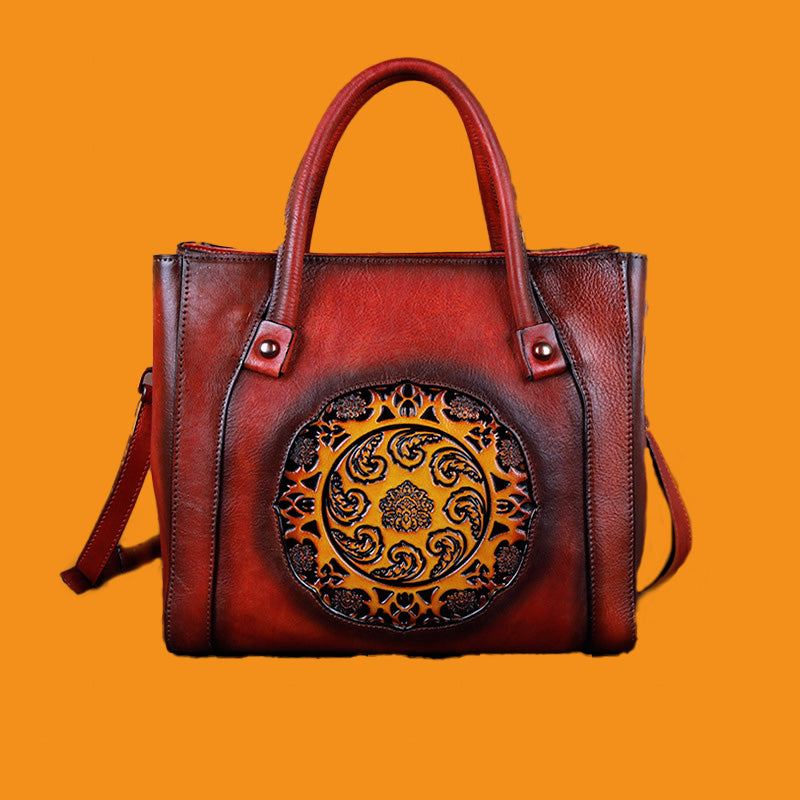 Brown leather handbag with decorative circular emblem on an orange background