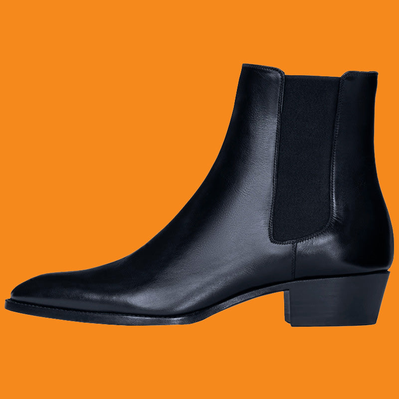 Black leather ankle boot on an orange background
