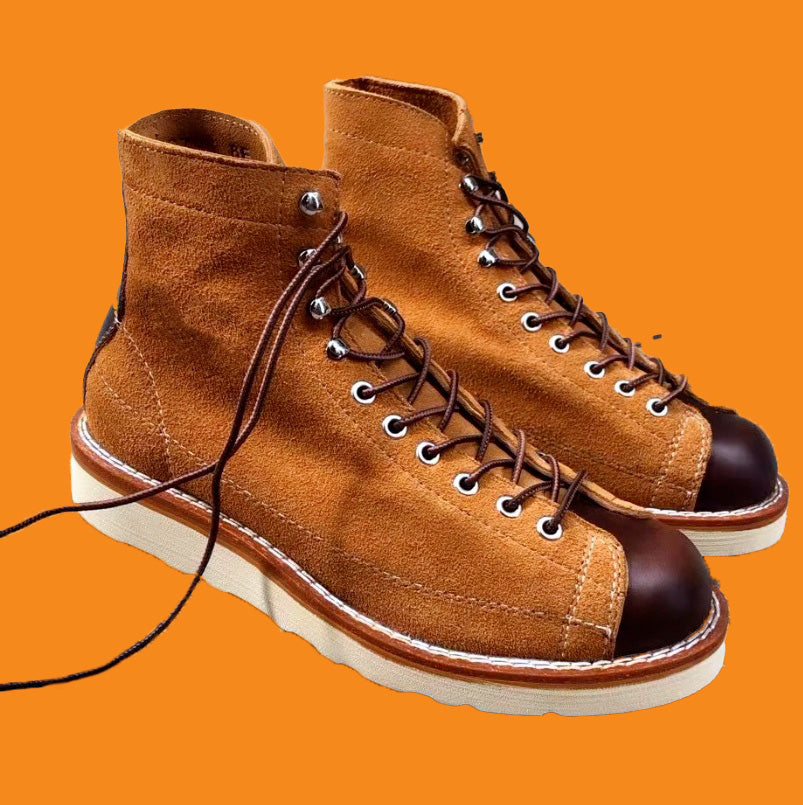 Pair of brown leather boots with white soles on an orange background