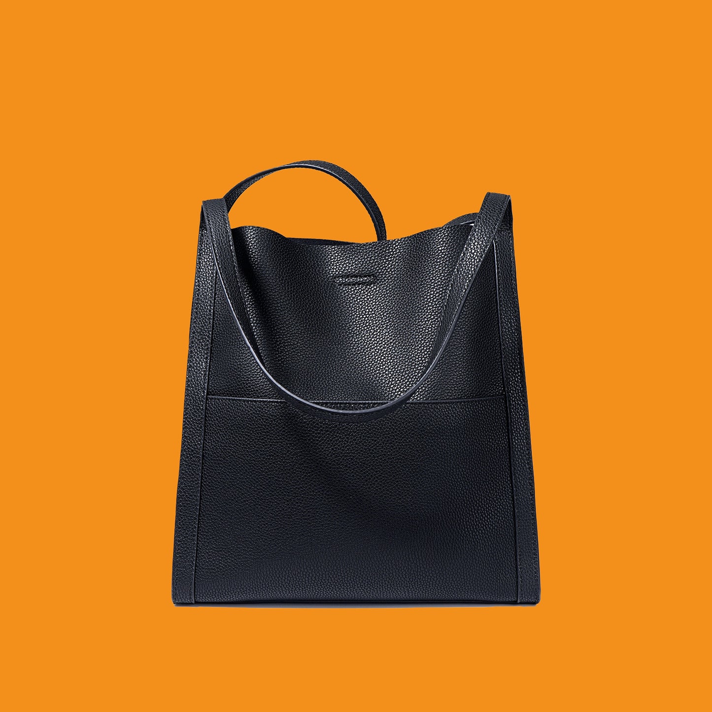 Black leather handbag on an orange background