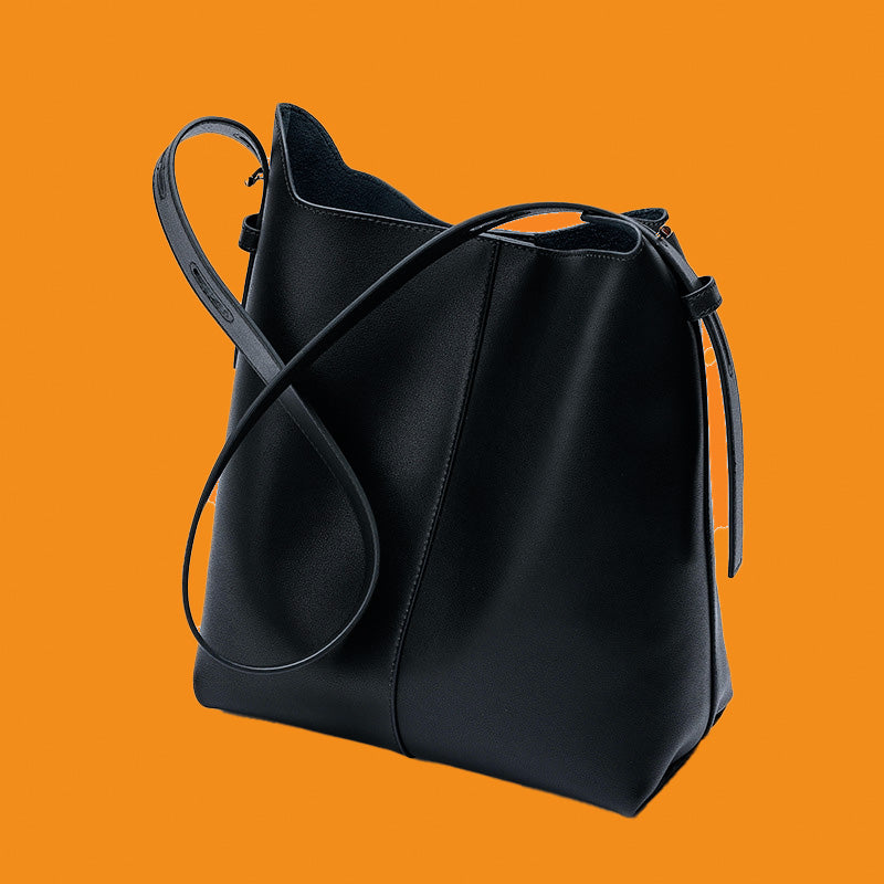 Black leather handbag on an orange background