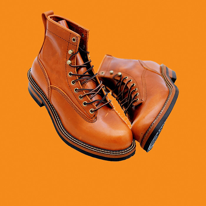 Pair of brown leather boots on an orange background