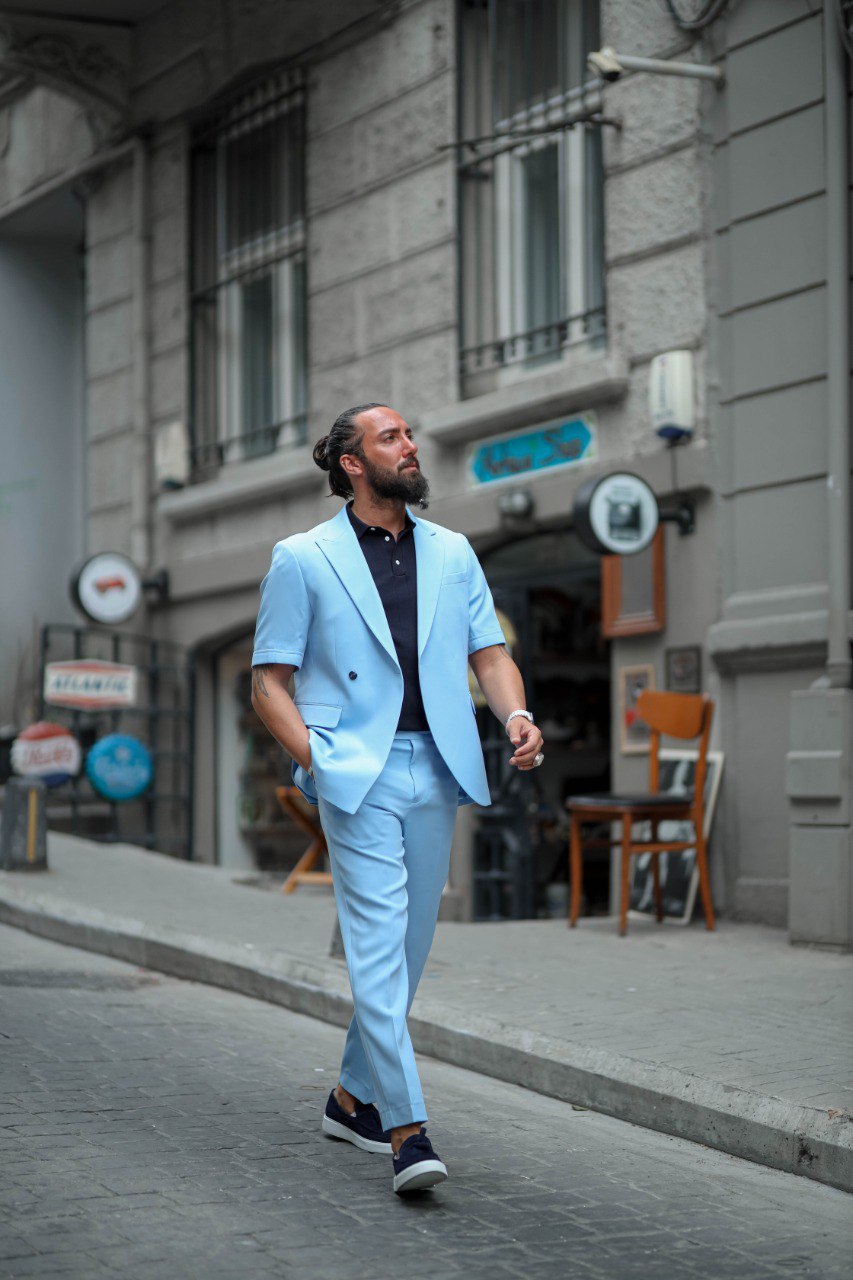 Man in light blue suit walking on a city street