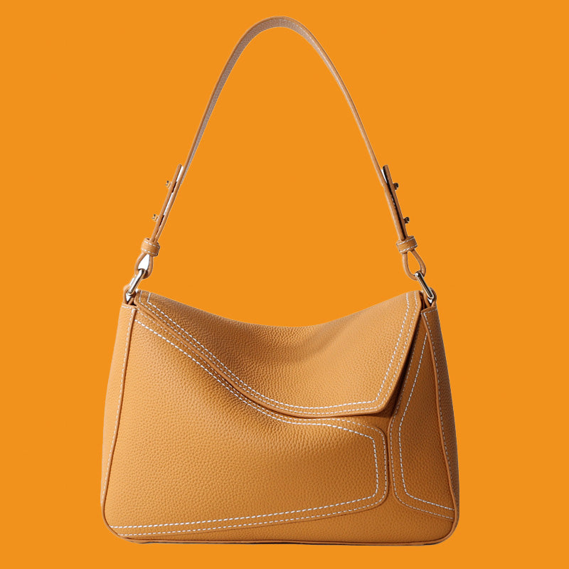 Brown leather handbag on an orange background