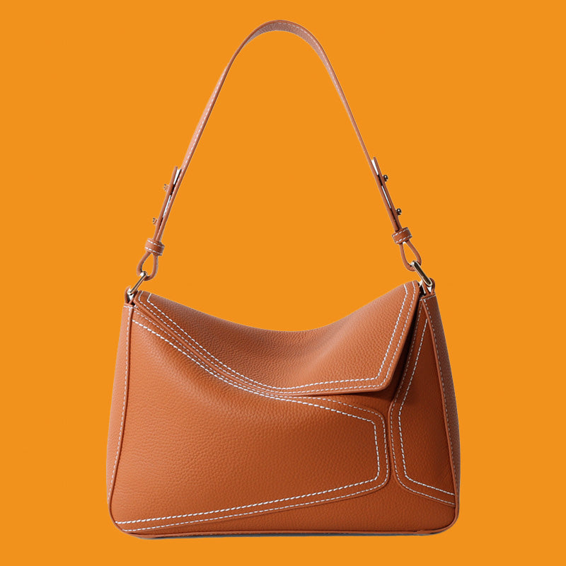 Brown leather handbag on an orange background