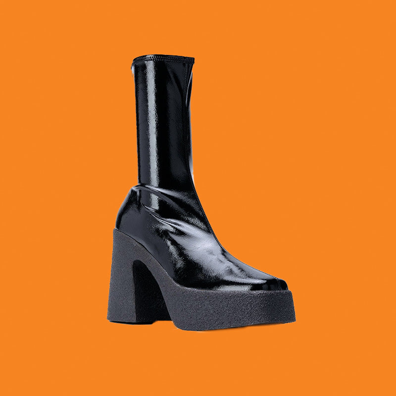 Black platform boot on an orange background