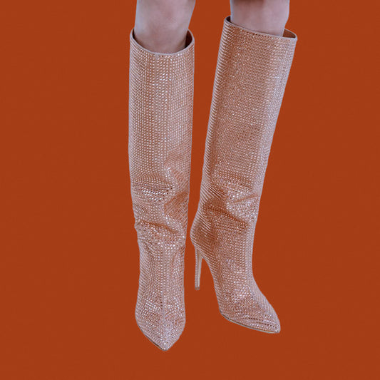 Sparkly knee-high boots on a solid orange background