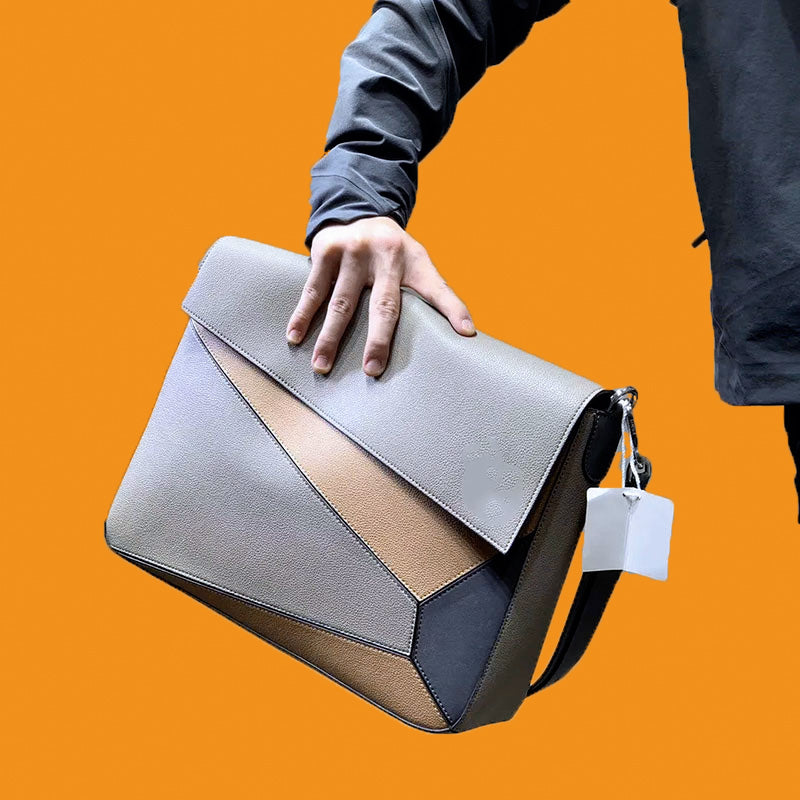 Handbag with geometric design held by a person against an orange background
