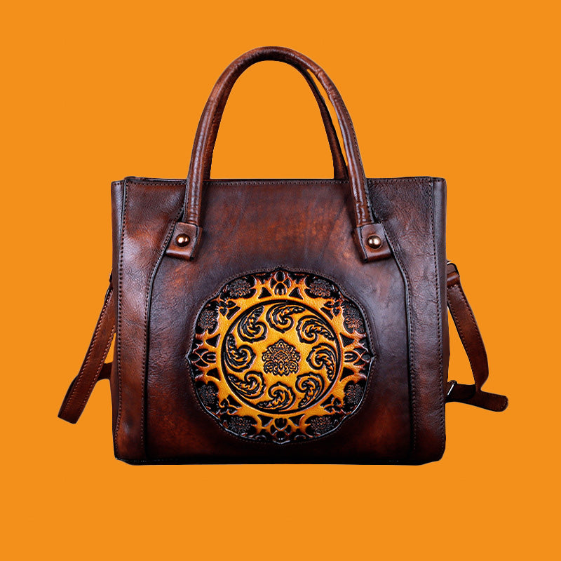 Brown leather handbag with decorative emblem on an orange background