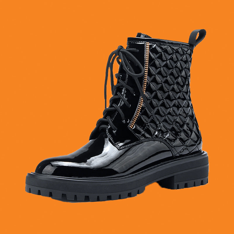 Black quilted boot with a zipper on an orange background