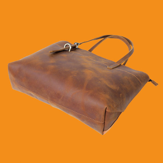 Brown leather bag on an orange background