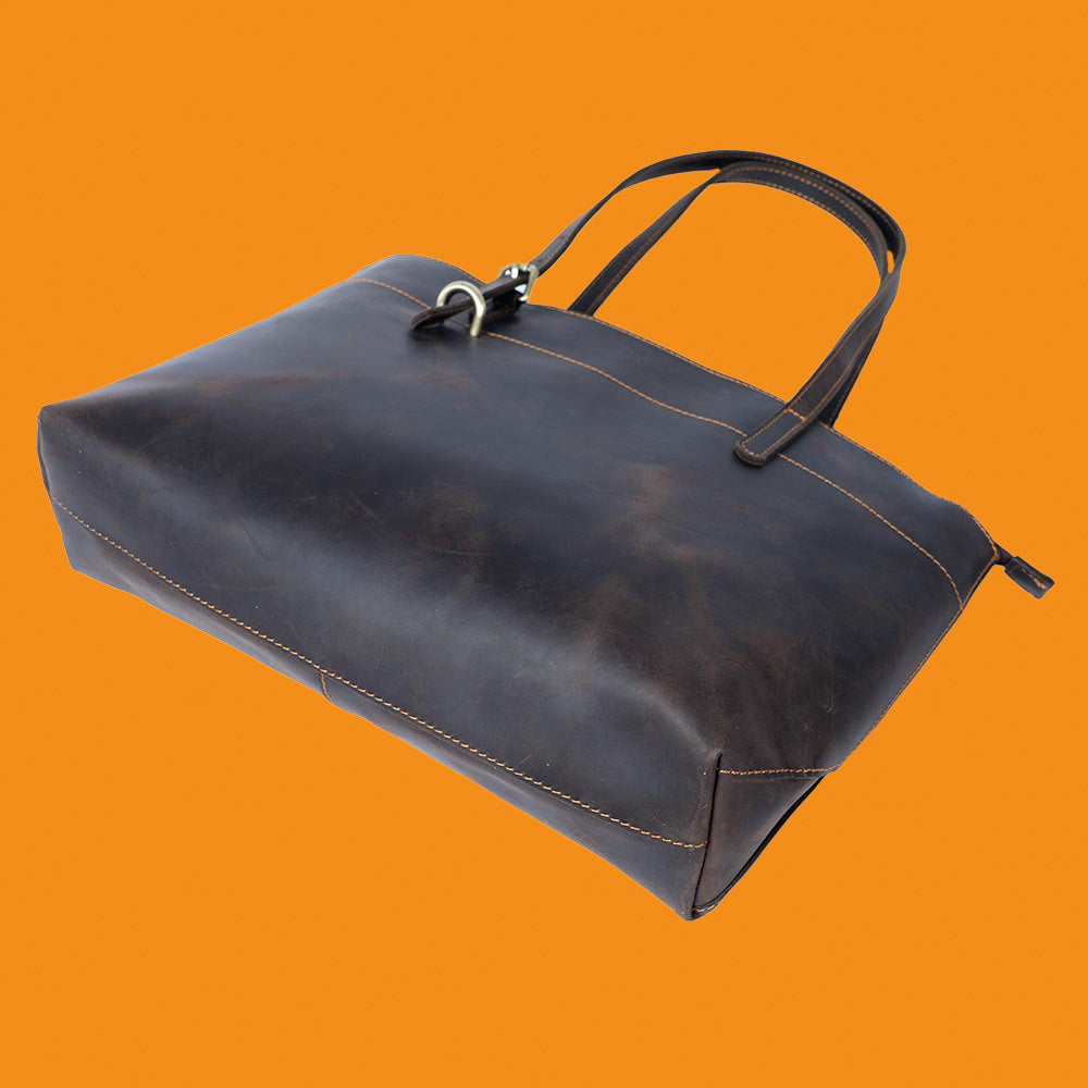 Brown leather bag on an orange background