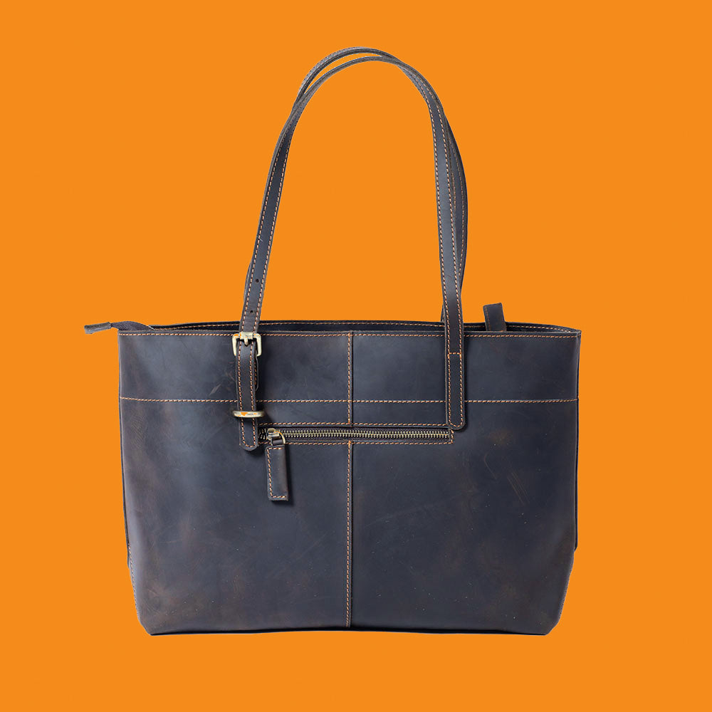 Blue leather tote bag on an orange background