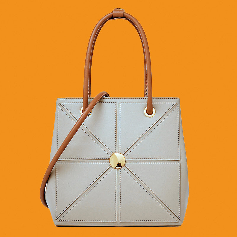 Light blue handbag with brown handles on an orange background