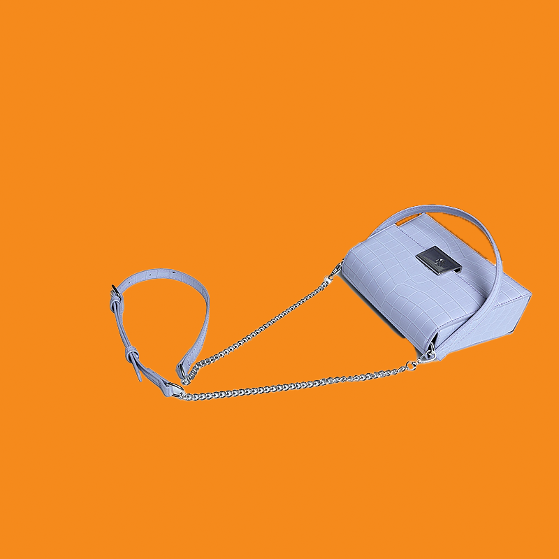 Light blue handbag with a chain strap on an orange background