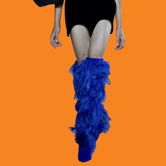Blue feathered leg warmers worn by a person on an orange background