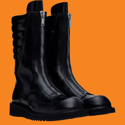 Black boots with zippers on an orange background