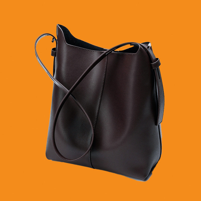 Black leather handbag on an orange background