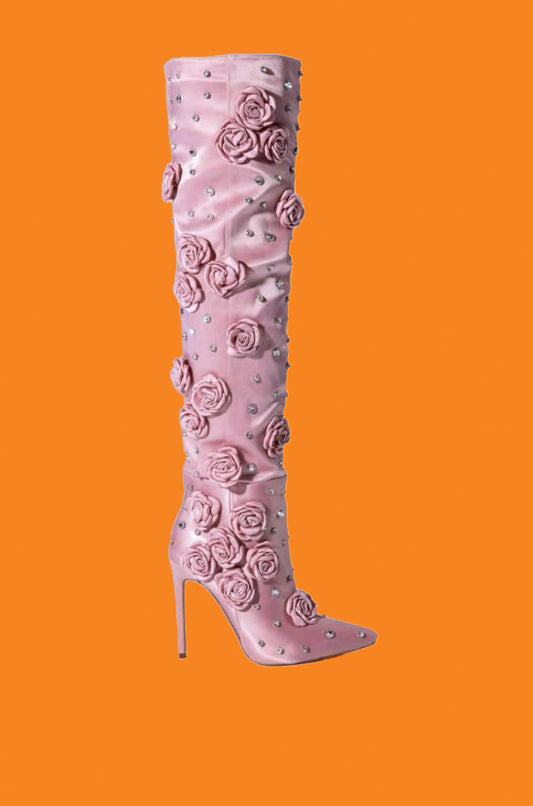 Pink knee-high boot with floral patterns on an orange background