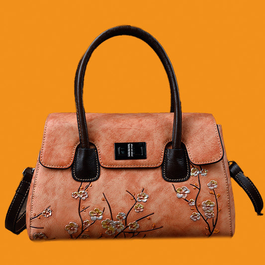 Pink handbag with floral embroidery on an orange background
