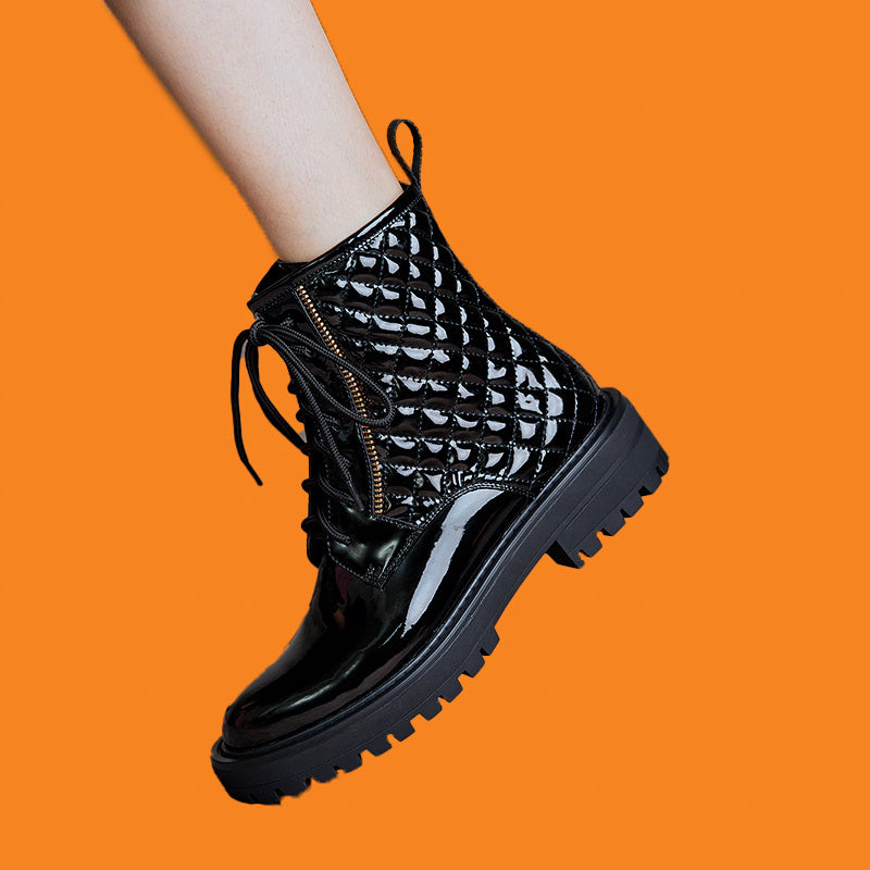 Black lace-up boots on a bright orange background