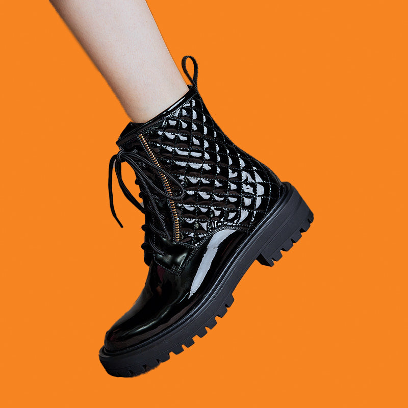 Black lace-up boots on a bright orange background