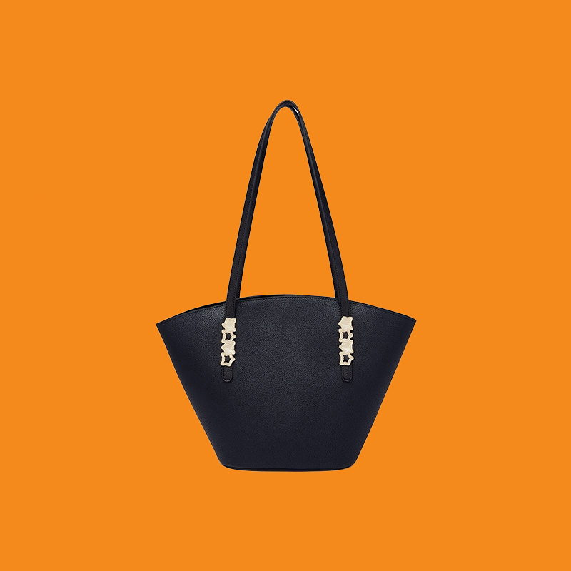 Black handbag with silver accents on an orange background