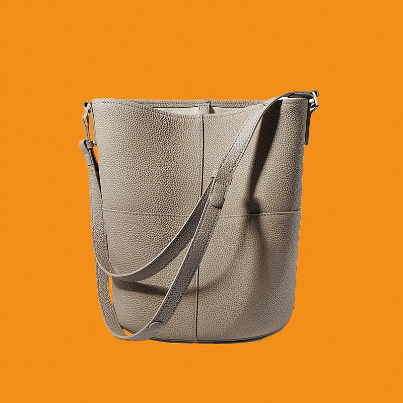 Gray leather handbag on an orange background
