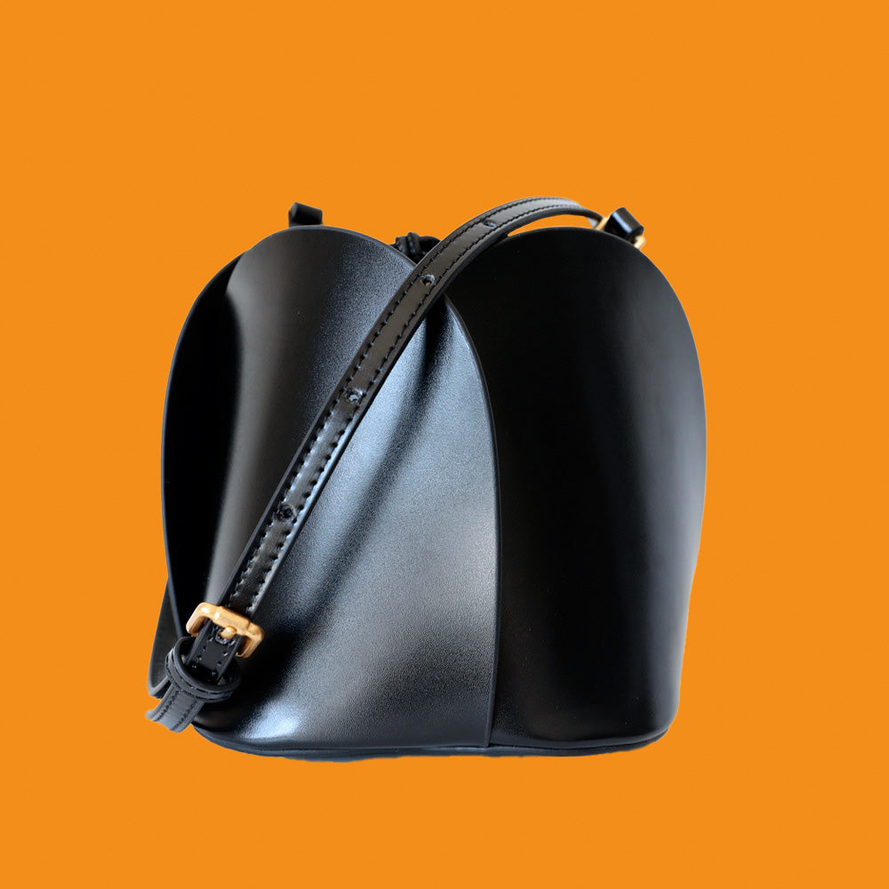 Black leather saddle bag on an orange background