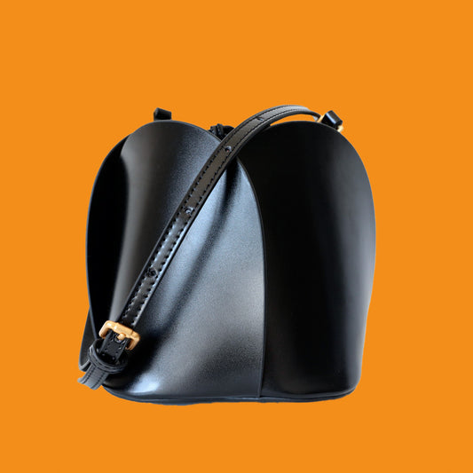 Black leather saddle bag on an orange background