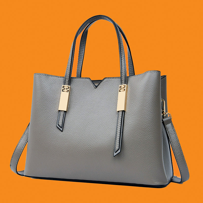 Gray handbag with gold accents on an orange background