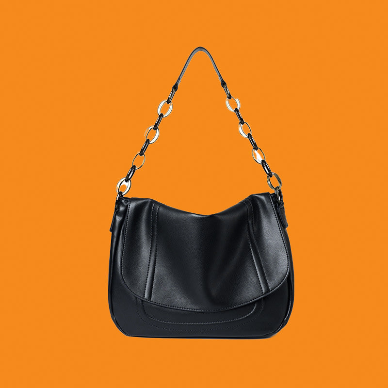 Black handbag with chain strap on an orange background