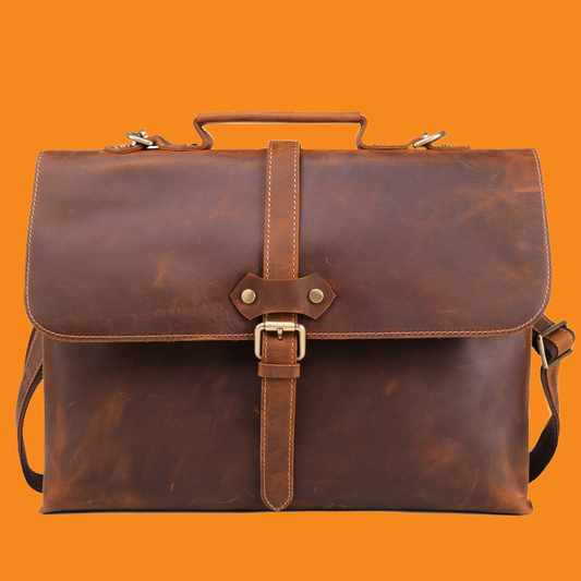 Brown leather satchel bag on an orange background