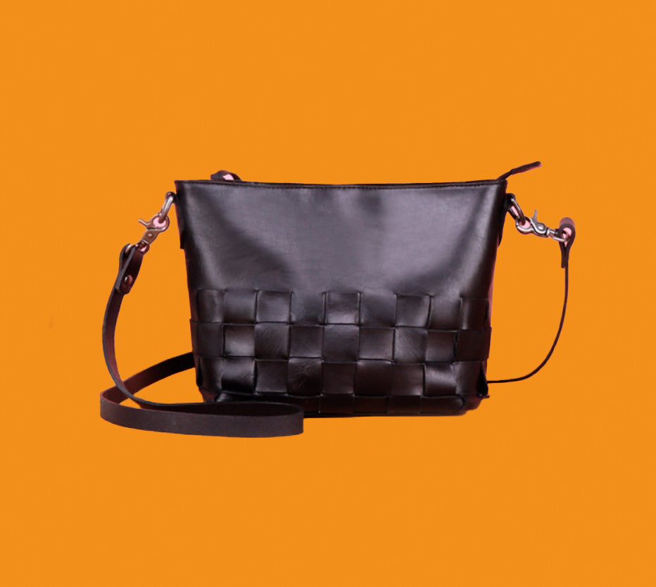Black woven handbag on an orange background