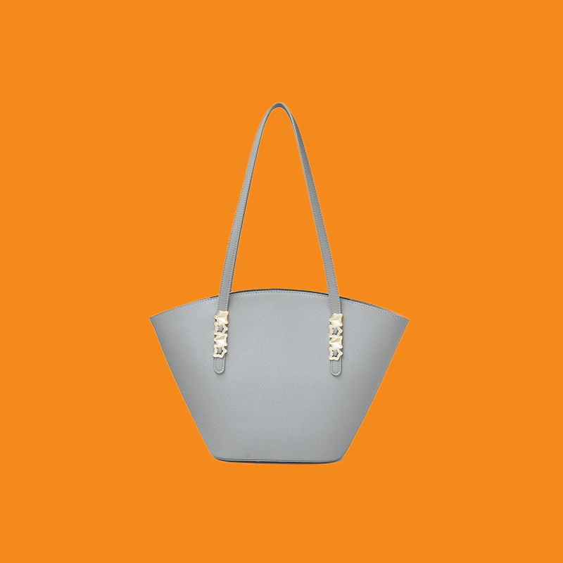 Gray handbag with decorative elements on an orange background