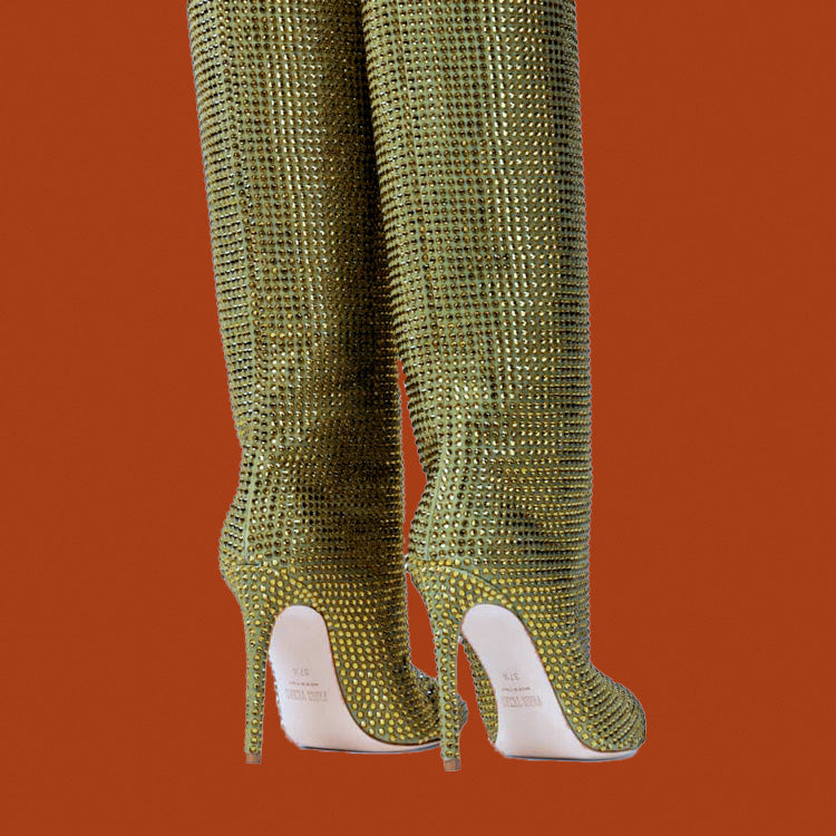 Green rhinestone knee-high boots on a solid orange background