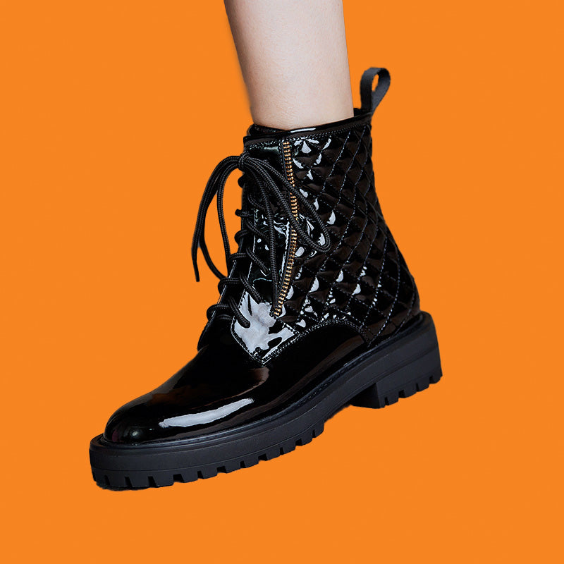 Black lace-up boot with a platform sole on an orange background