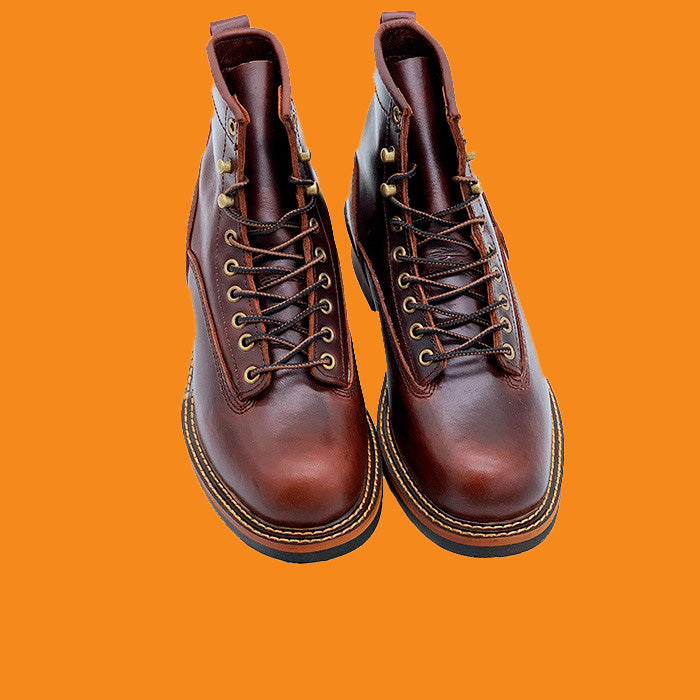 Pair of brown leather boots on an orange background