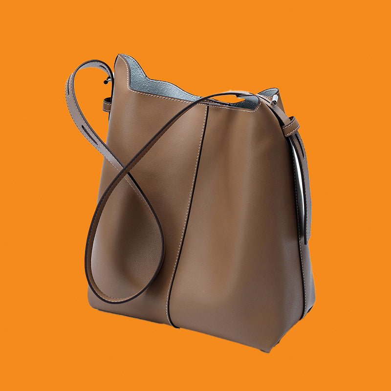 Brown leather handbag on an orange background