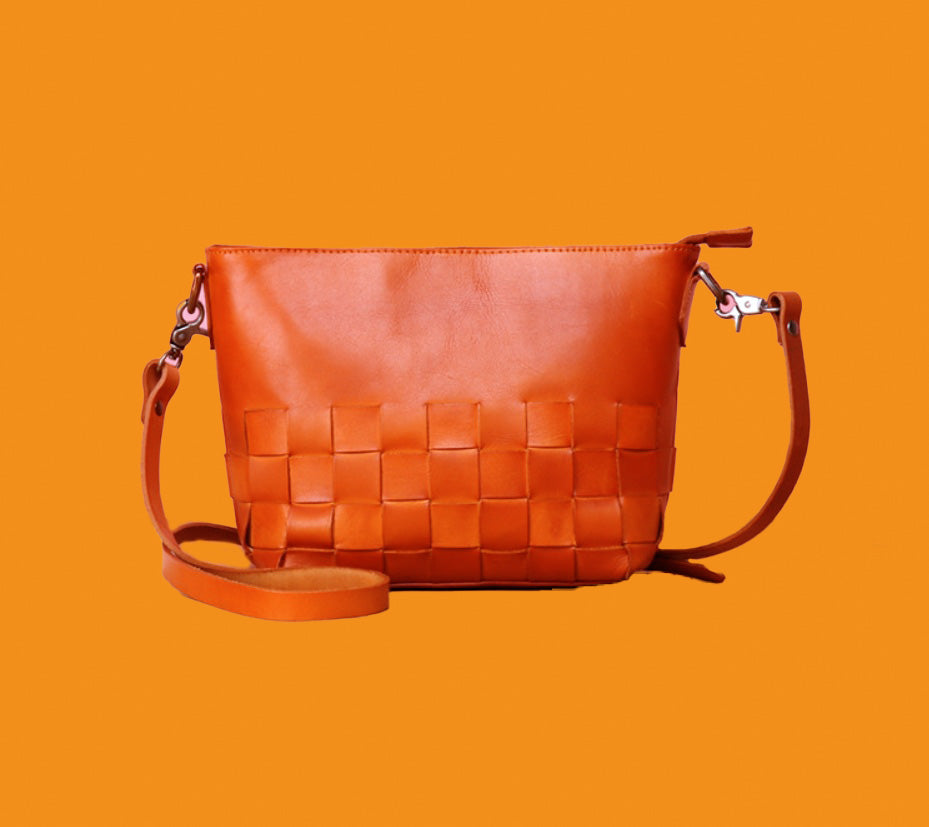 Brown woven handbag on an orange background