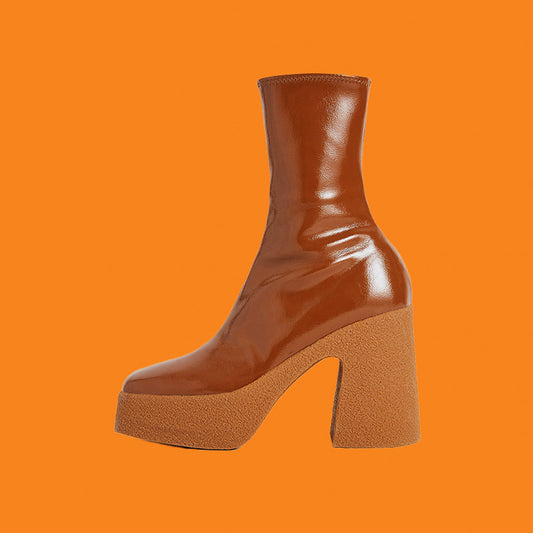 Brown platform boot on an orange background