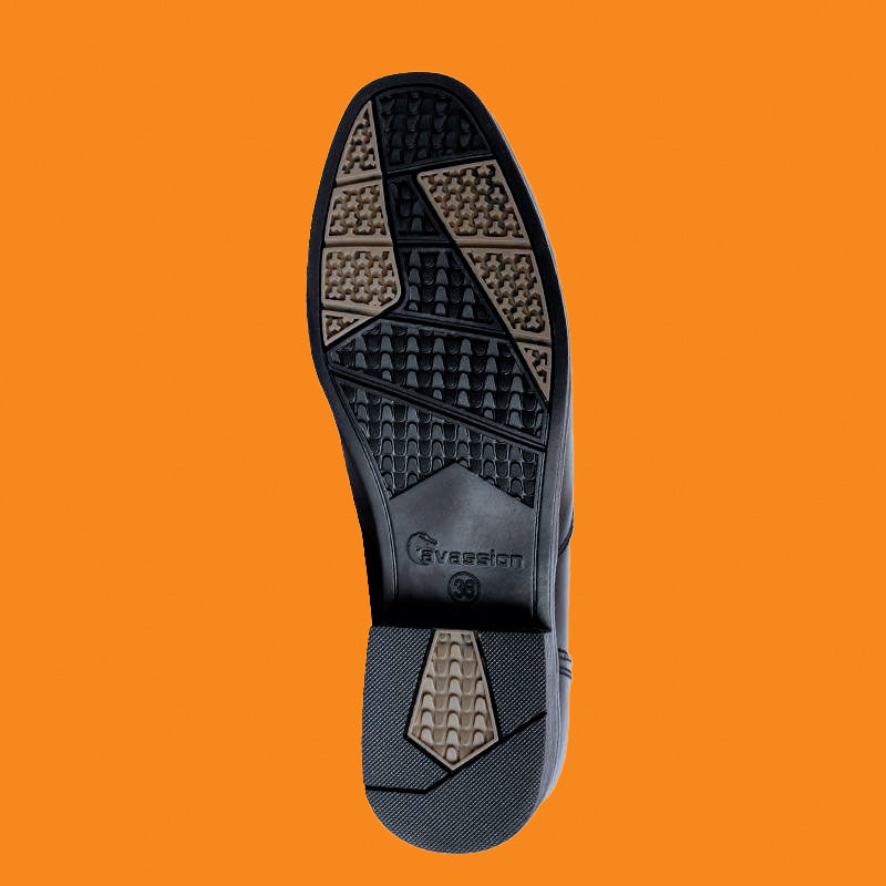 Black shoe sole with patterned tread on an orange background
