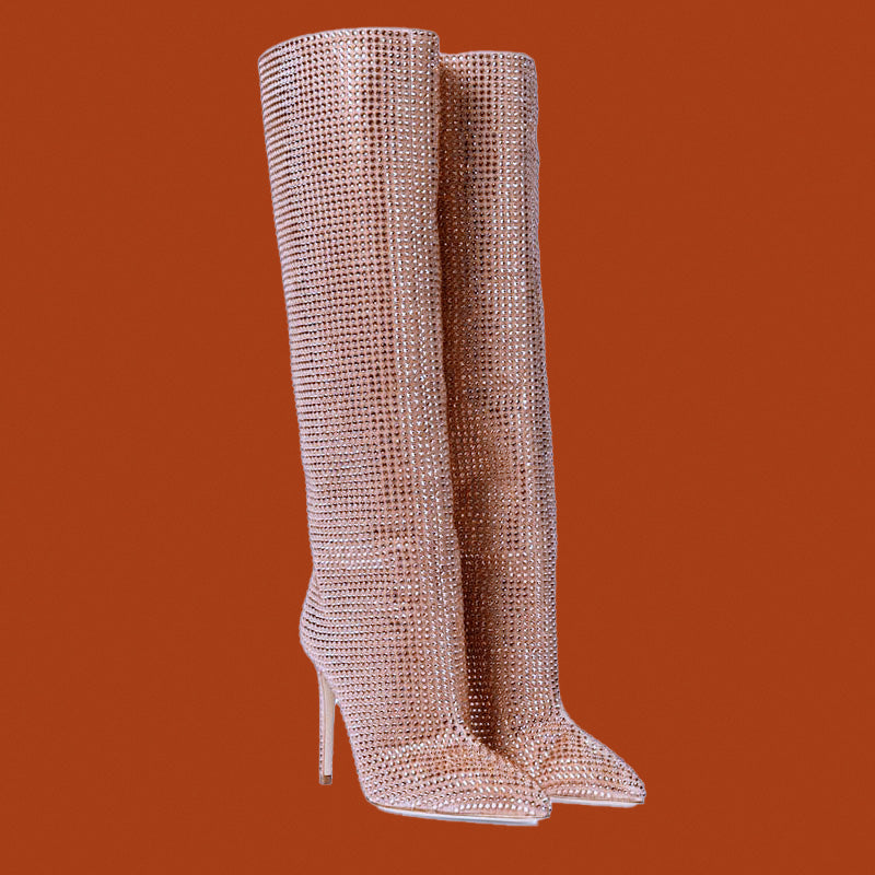 Pair of rose gold knee-high boots on an orange background
