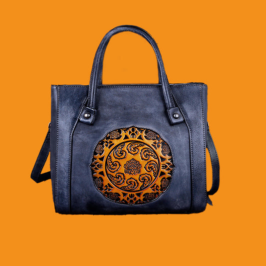 Blue handbag with decorative emblem on an orange background