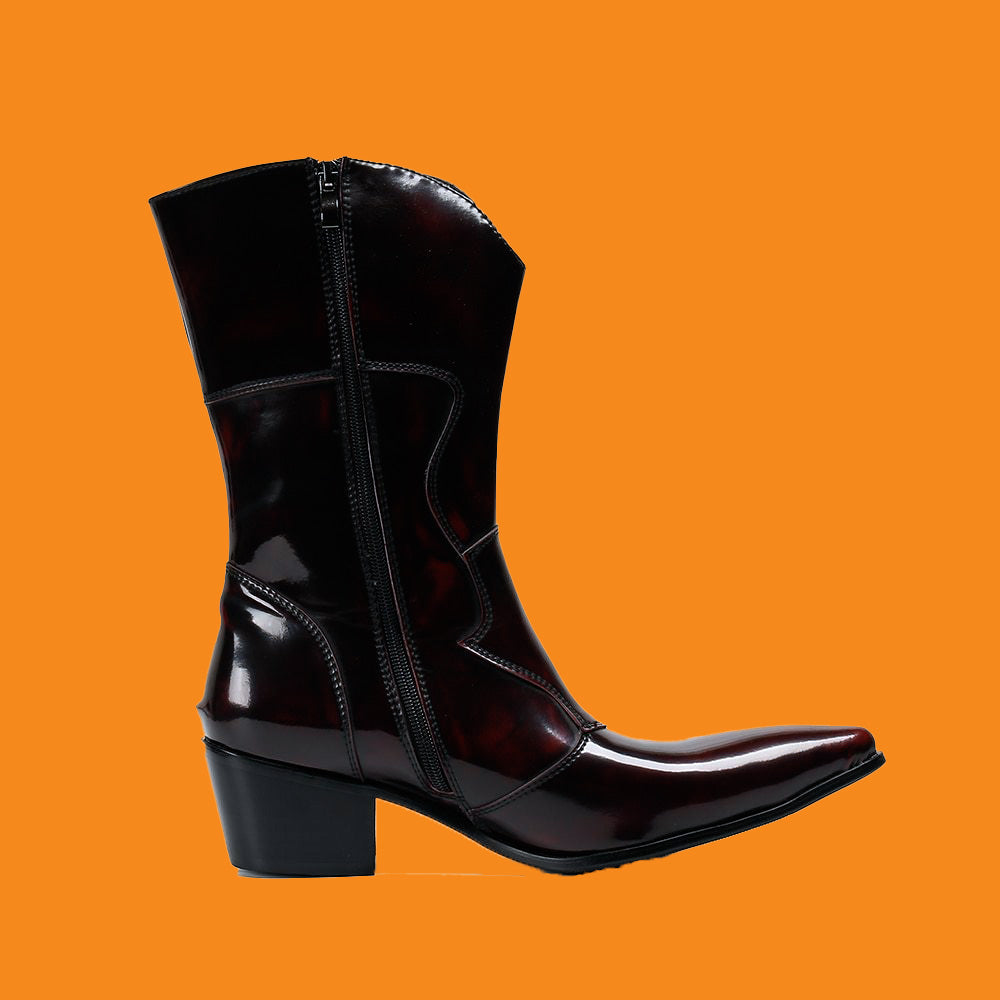 Black patent leather cowboy boot on an orange background